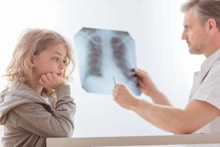 Doctor examining lung's x-ray of cute little child in the hospitalの写真素材