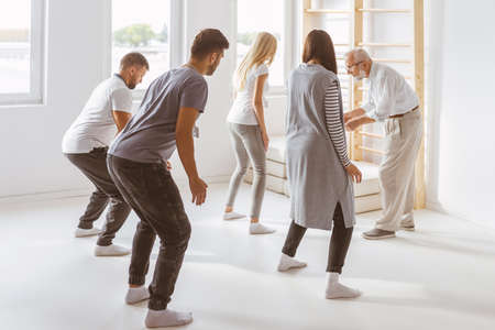 Group of students on bioenergy therapy session with older teacherの写真素材