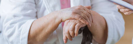 Close-up of older woman's hand holding a railwayの写真素材