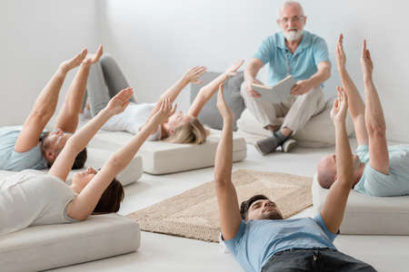 Group of young people relaxing and breathing on bioenergy therapyの写真素材