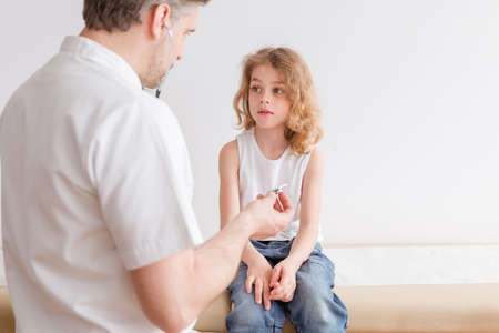 Ill child with pneumonia symptoms and professional doctor in the hospitalの写真素材