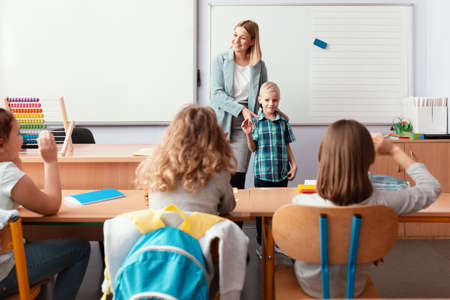 Young happy teacher introduces the new student to the classの写真素材