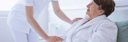 Young supportive nurse helping her sick patient in a hospitalの写真素材