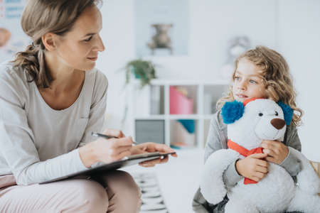 Young boy talking with school psychologist during therapy sessionの写真素材