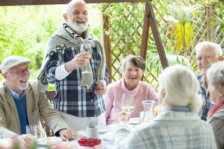 Happy group of retired friends having fun during birthday party at the gardenの写真素材