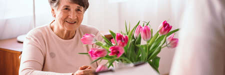 Smiling senior lady listening to her doctor in the nursing homeの写真素材