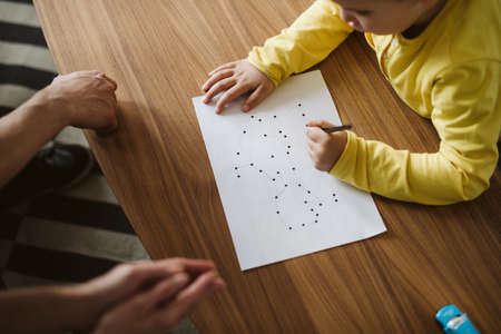 Young boy drawing a picture connecting dots on a psychotherapy sessionの写真素材
