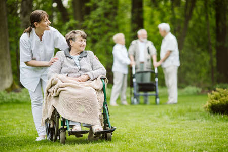 Happy senior woman and helpful caregiver, nursing home concept photosの写真素材