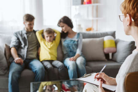 Woman and man with their son on a family psychotherapy with psychologistの写真素材