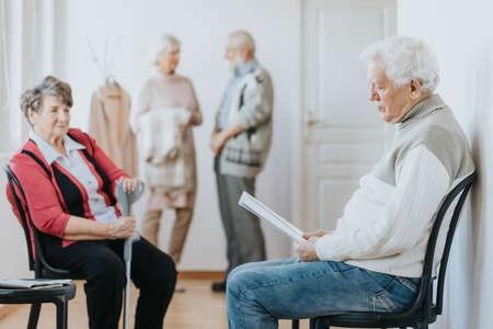 Two older people waiting in a line in a clinicの写真素材