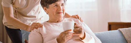 Older woman drinking tea in the living room in a nursing homeの写真素材