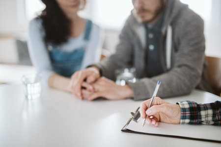 Young man holding his wife's hand during psychotherapy sessionの写真素材