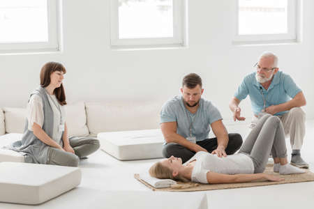 Young man working on woman's body using bioenergetic therapyの写真素材