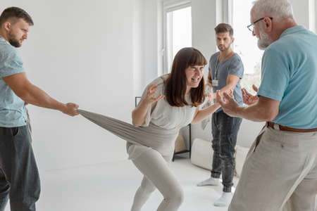 Young woman screaming releasing her anger on group therapyの写真素材