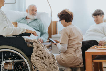 Helpful nurse switching on a professional bed in a nursing homeの写真素材