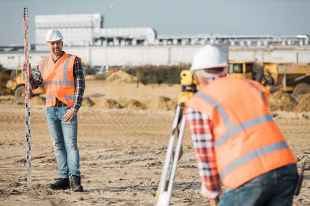 Two geodesists measuring the surface using tachometersの写真素材