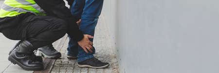 Two police officers detaining a drug dealer, copy space on the empty gray wallの写真素材