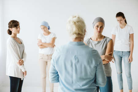 Meeting of group of women talking together during psychotherapy with senior counselorの写真素材
