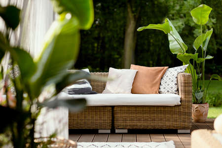 View on pretty cozy garden with rest area on a wooden porchの写真素材