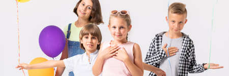 Young girl in pink dress and her friends on her birthday partyの写真素材