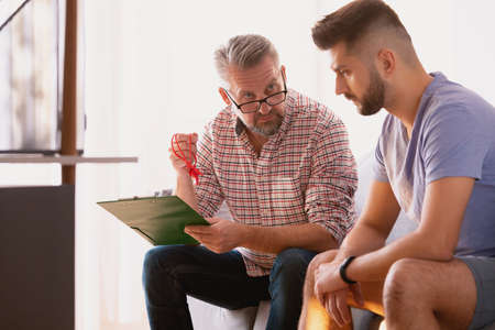 Psychotherapist talking with a man about the accidentの写真素材