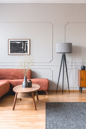 Stylish tall gray lamp in elegant living room interior with comfortable brown corner sofaの写真素材