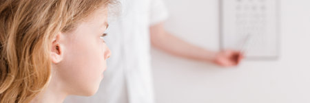 Ophthalmologist shows a small boy an eye test chartの写真素材