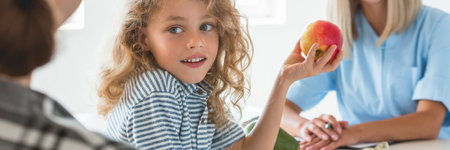 Little boy playing with fruit during a visit to a dietitianの写真素材