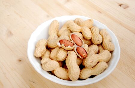 jar with peanuts upward wooden table