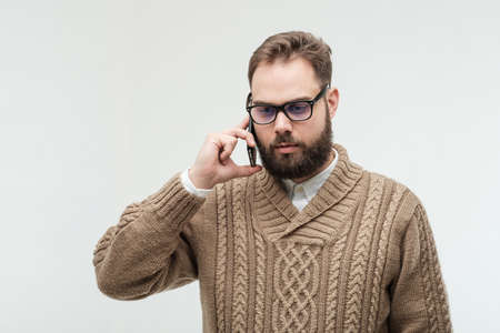 Upset handsome man talking on a cellphone and recieved bad newsの写真素材