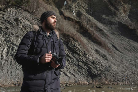 Portrait of a bearded traveller with camera