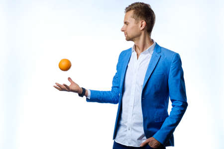 Man throwing orange isolated on whiteの写真素材