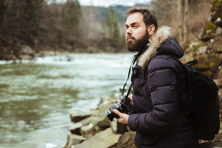 Man traveler photographer with camera photographing the riverの写真素材