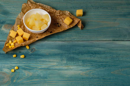 Bunch of Pineapple and cheese cut in dices on blue wooden backgroundの写真素材