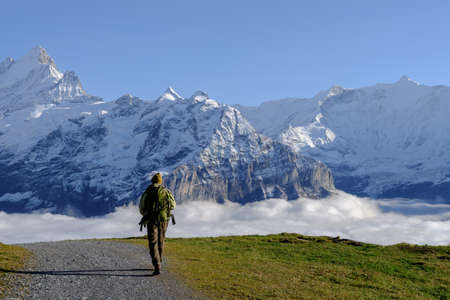 Tourist walking with a backpack in the mountains at Grindewald, Switzerland. Mountain hiking in the...