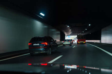 Cars driving fast through modern European tunnel. Switzerland