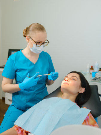 Female dentist with cartridge syringe getting ready to use anesthesia before teeth treatmentの写真素材
