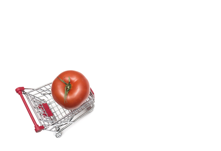 Buying a tomatoes from supermarket, Tomato in shopping cart, shoping cart isolated on white backgroundの写真素材