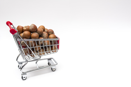 Buying a peanuts from supermarket, peanuts in shopping cart, shoping cart isolated on white backgroundの写真素材