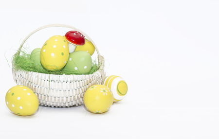 Easter eggs in a basket isolated on a white backgroundの写真素材
