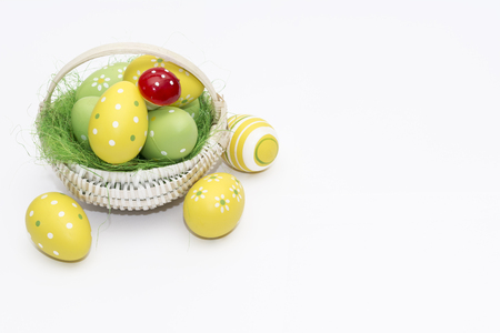 Easter eggs in a basket isolated on a white backgroundの写真素材