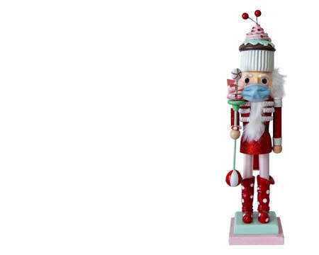 candy themed nutcracker doll in red suite and cupcake hat wearing a face maskの写真素材