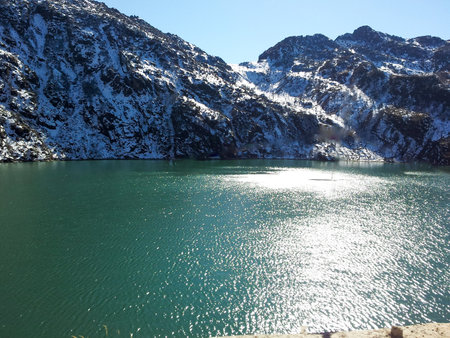 A blue sea passing by the snow covered mountains.の写真素材