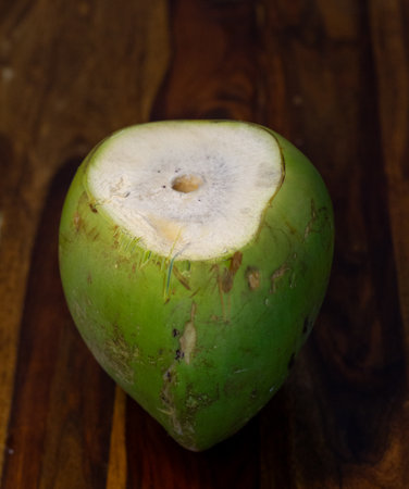 A close-up photo of a tender coconut against a wooden platform.の写真素材