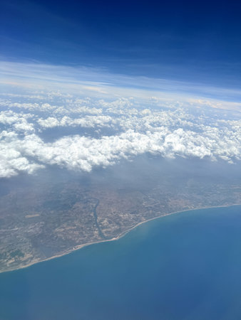 View of a sea,land and clouds from a window of an airplaneの写真素材