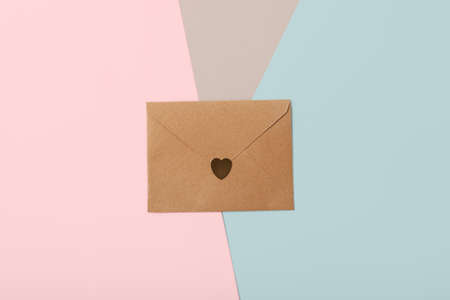 Craft paper envelope on the red background with golden confetti on background.Saint Valentines day...