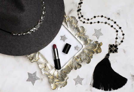 A composition of women's stuff - Fedor's gray hat, lipstick, sotuar.Advertising campaign concept for cosmetics. Copy space for design or text.の写真素材