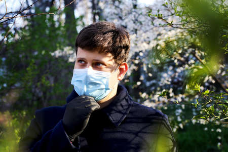 Man in blue medical maskand black gloves outdoor.Protecting health from various viruses and...