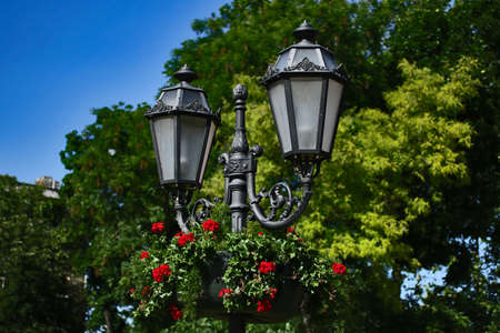 Antique lamppost in the park.Bright blooming flowers on the background.Beautiful city places.Copy space for text.Summertime.の写真素材