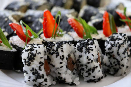 Set of sushi rolls-traditional japanese dish.Top view of assorted sushi,decorated with slices of strawberry.Food background.の写真素材